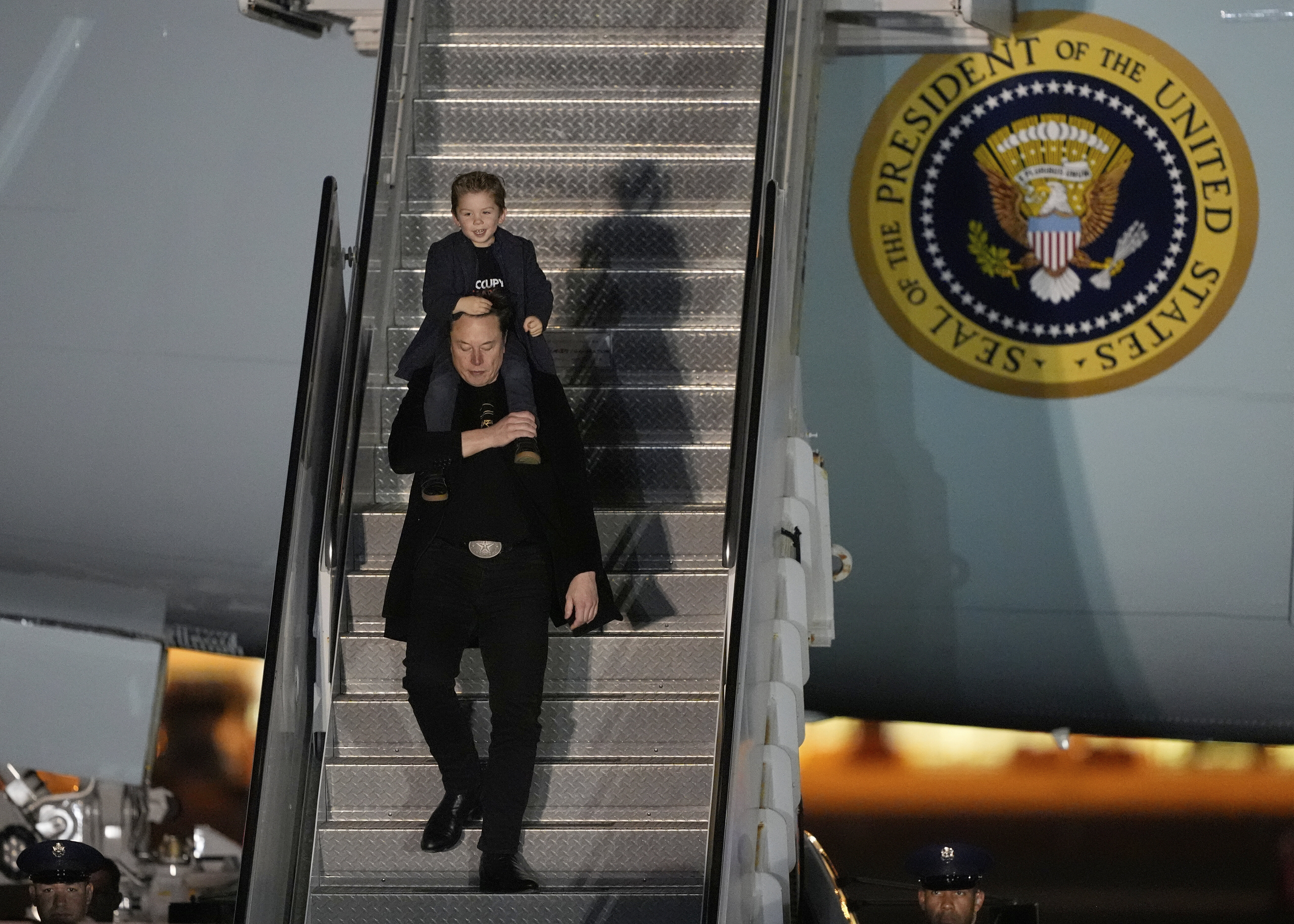 Elon Musk carries his son X Æ A-Xii as they arrives on Air Force One with President Donald Trump, not pictured, at Miami International Airport, Saturday, April 12, 2025, in Miami, Fla. (AP Photo/Manuel Balce Ceneta)