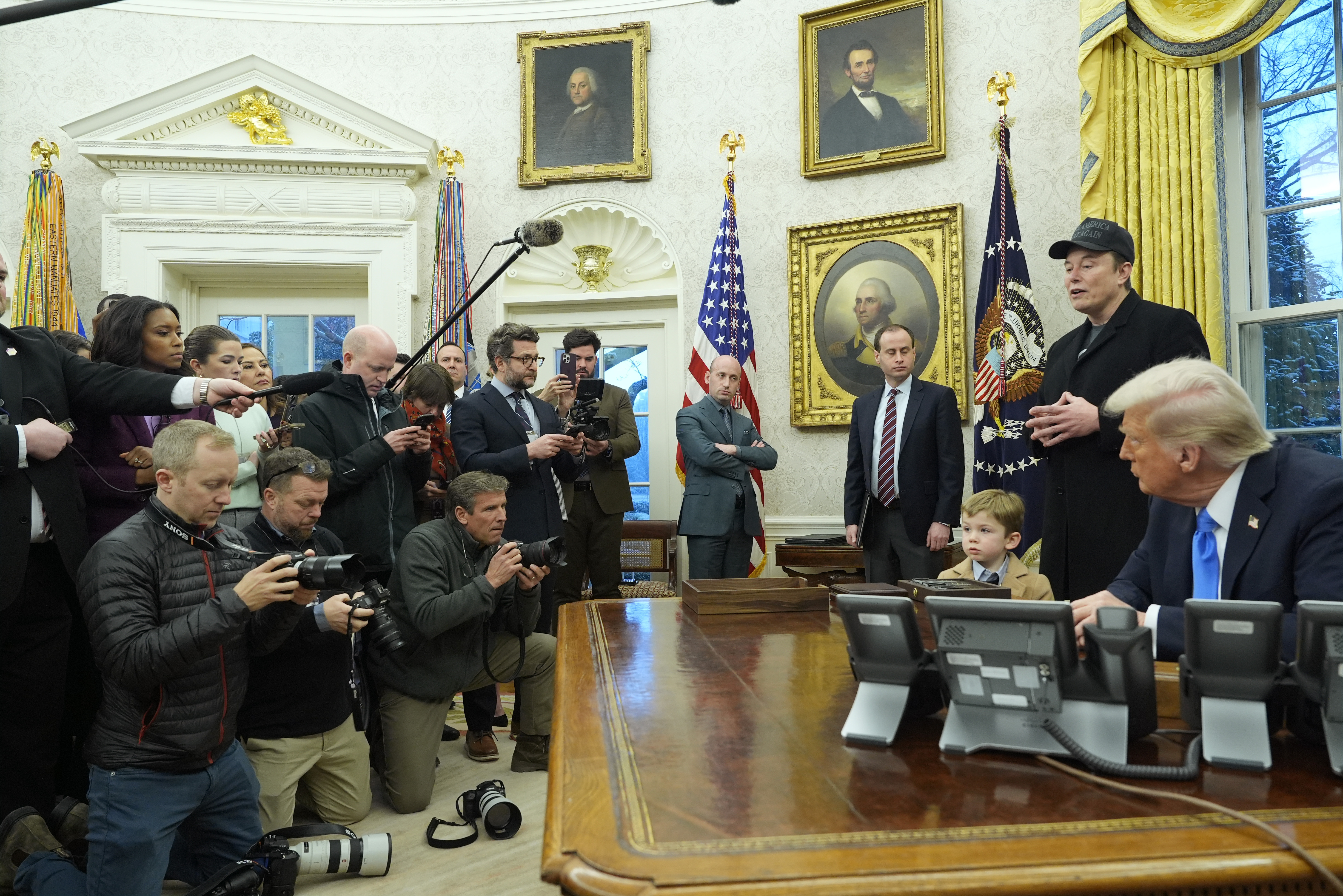 Elon Musk speaks during an event in the Oval Office as President Donald Trump and Musk's son X Æ A-Xii, listen at the White House, Tuesday, Feb. 11, 2025, in Washington. (AP Photo/Alex Brandon)