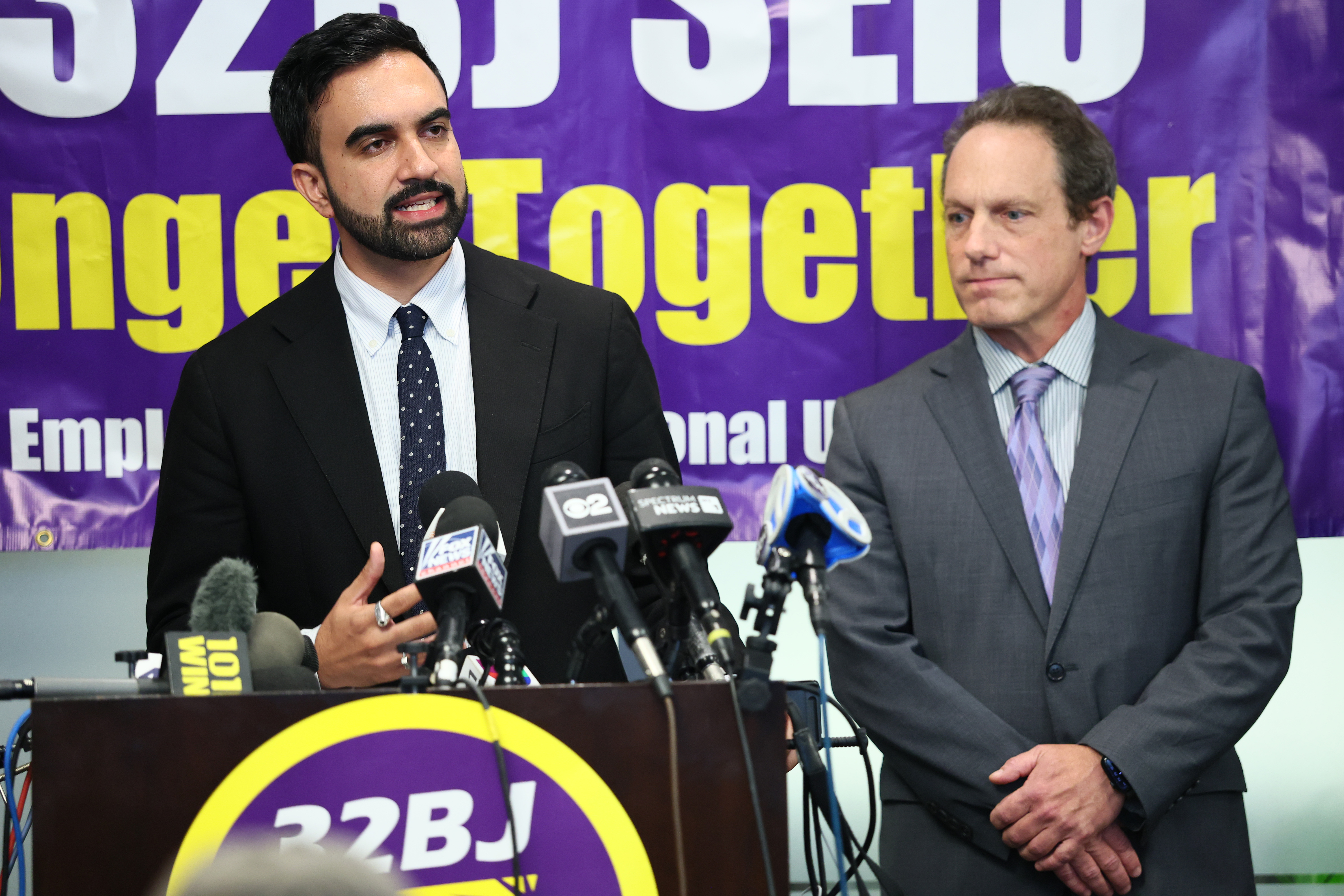 New York City Mayoral Candidate Zohran Mamdani speaks as 32BJ President Manny Pastreich listens during a press conference on the victims of the Midtown shooting at 32BJ SEIU headquarters on July 30, 2025 in New York City. 
