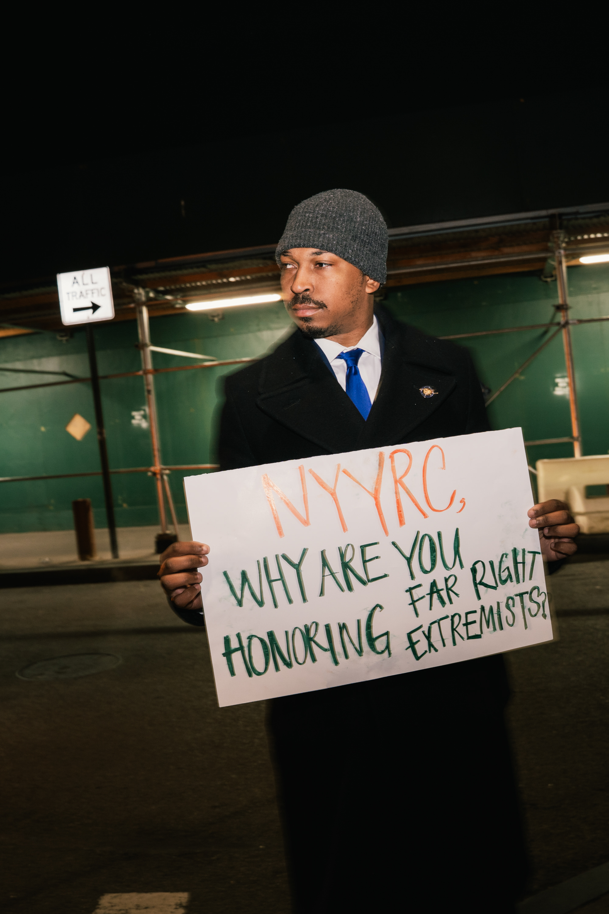 Assemblymember Jordan Wright stands during a protest outside the event.