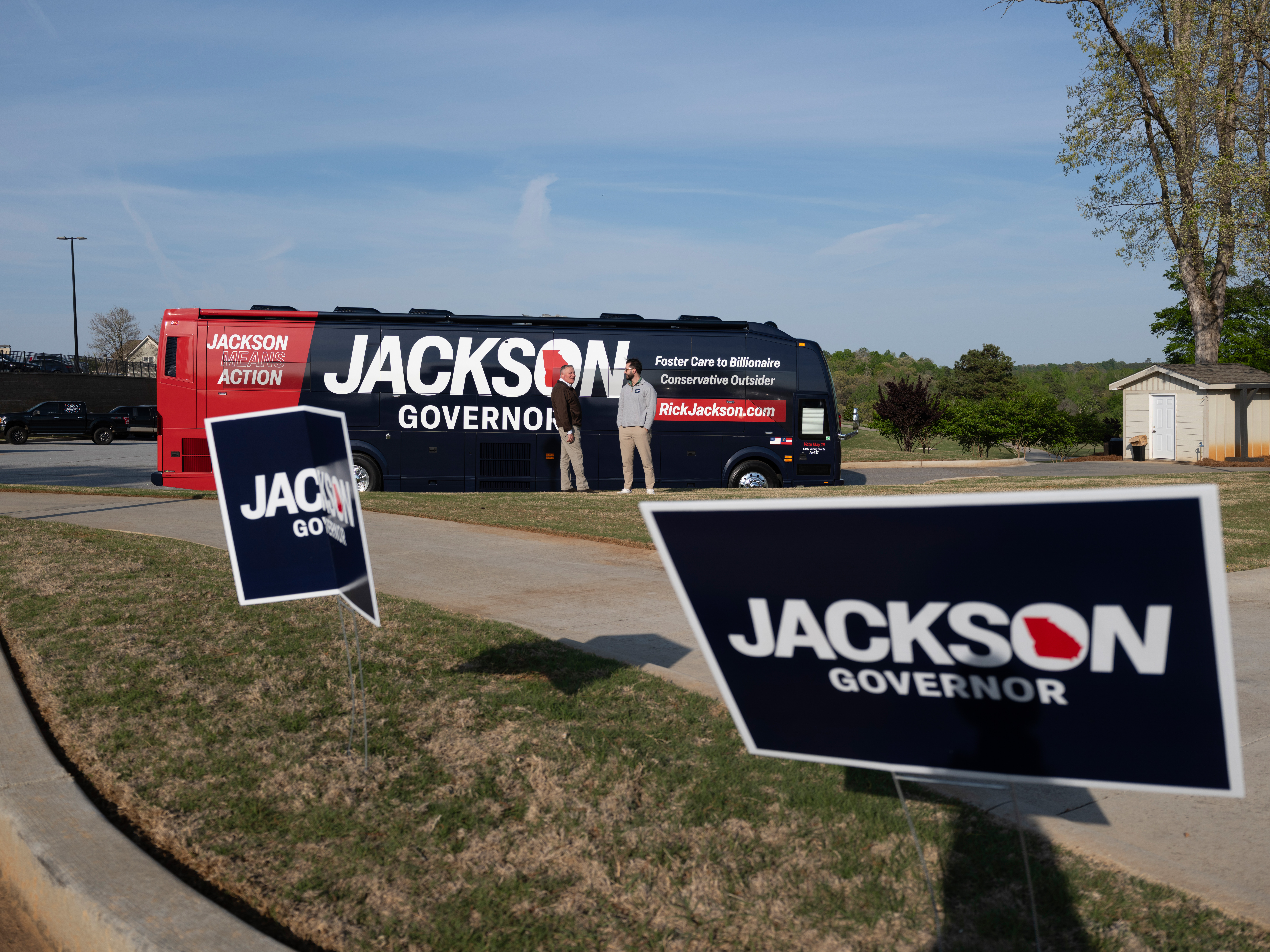 Jackson’s campaign tour bus is seen alongside yard signs in the parking lot outside the Chimney Oaks Golf Club.