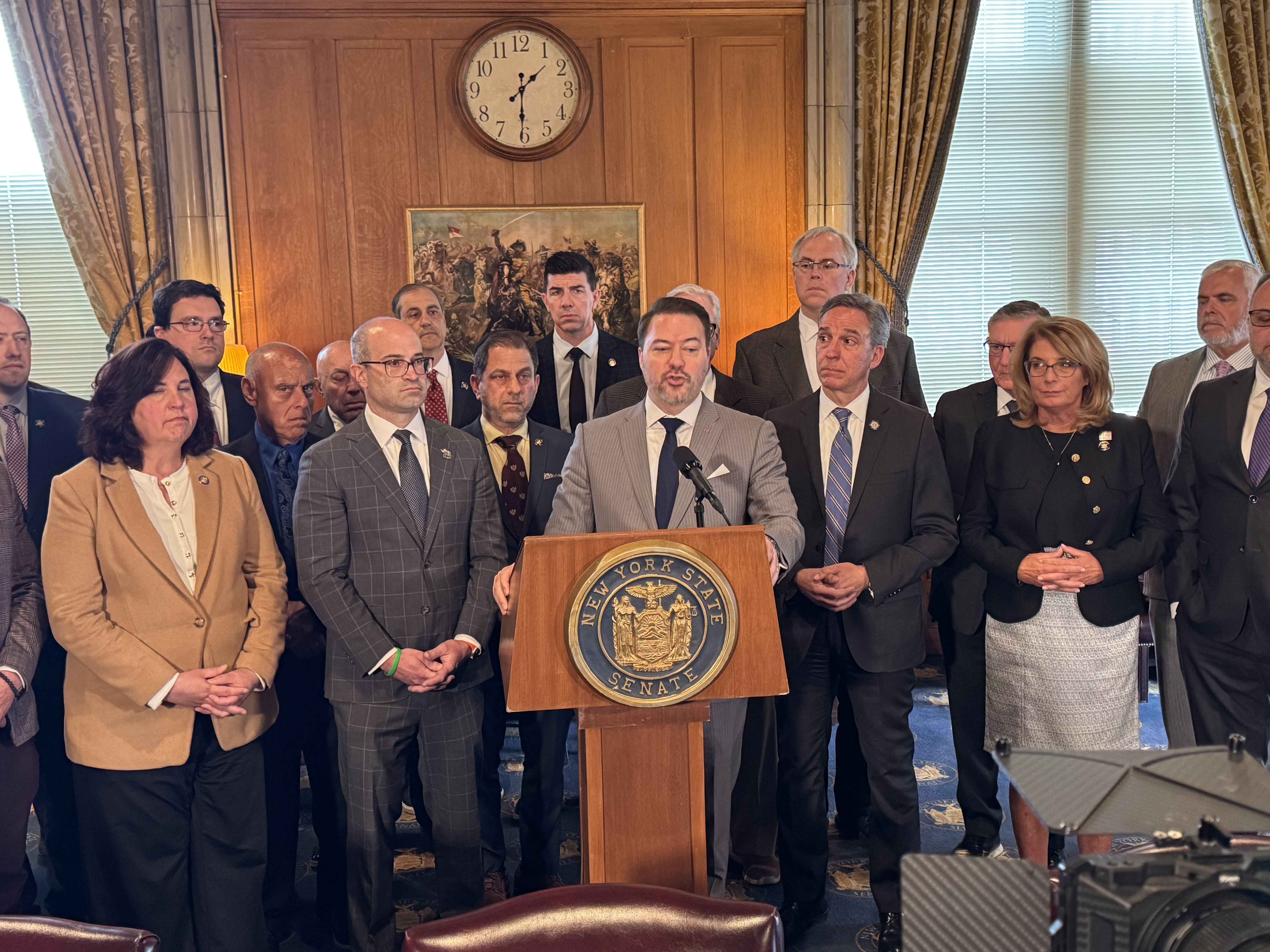 New York Senate Minority Leader Rob Ortt (center) speaks at podium alongside Assembly Minority Leader Ed Ra (left) as GOP legislators call for a bill to let Bruce Blakeman rejoin the public financing system.