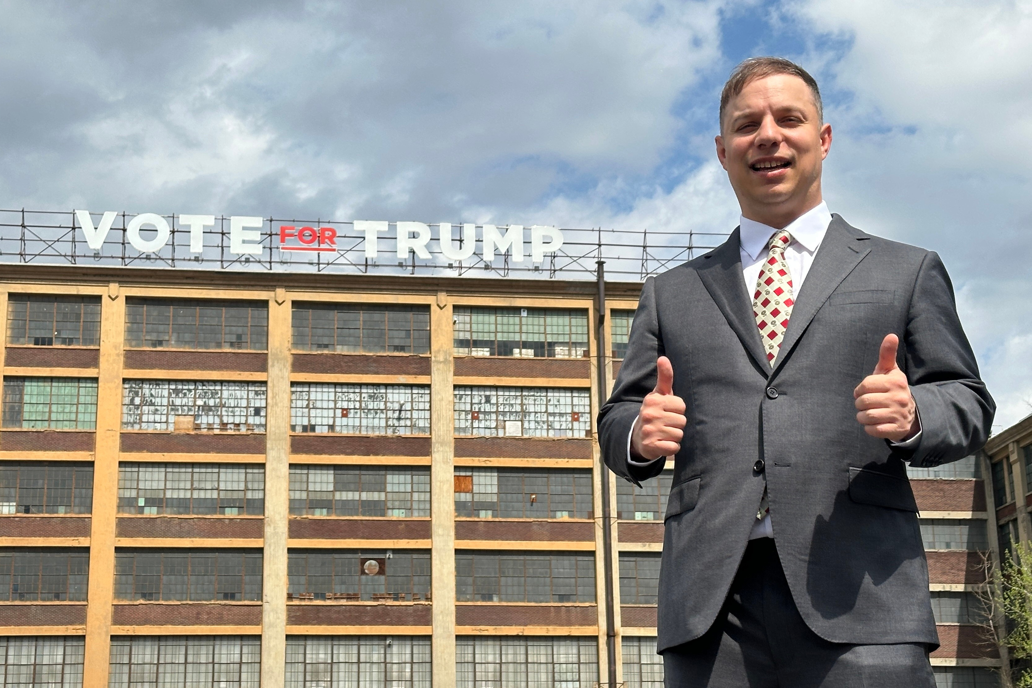 Anthony Constantino, a Republican candidate for Congress, stands in front of a 