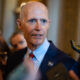 Rick Scott says he’s just trying to help