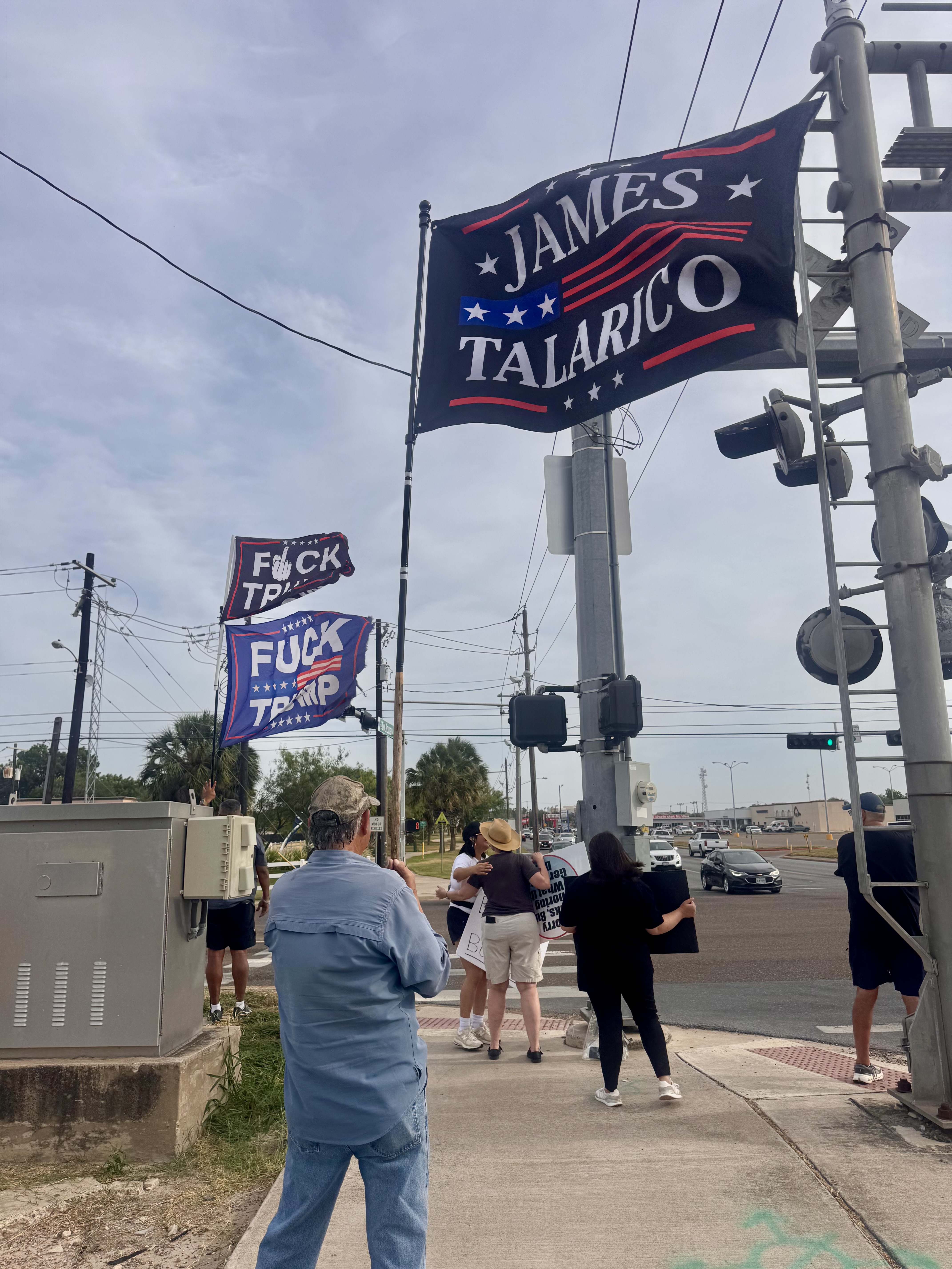 Supporters of Democratic Texas Senate nominee James Talarico carry flags.