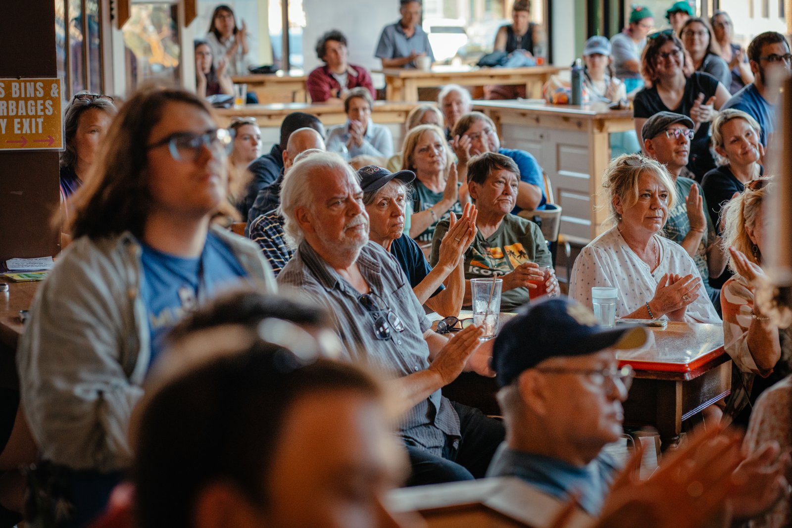 People applaud as they listen to Hong speak during an event at Paradigm Coffee and Music in Sheboygan on Aug. 8.