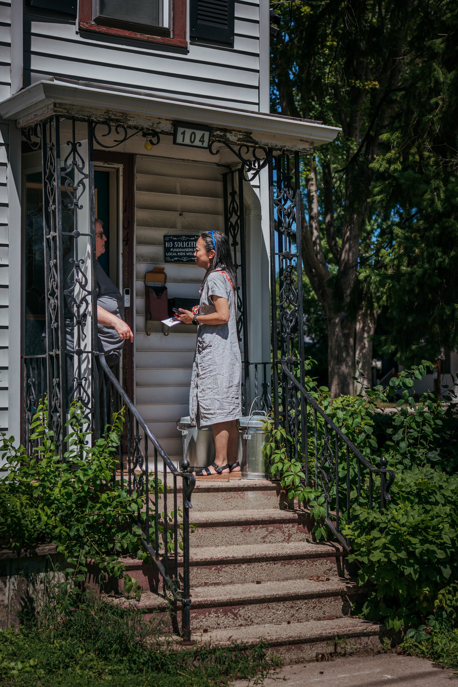 Hong speaks with Heidi Meyer while knocking on doors during a canvassing event in Appleton.